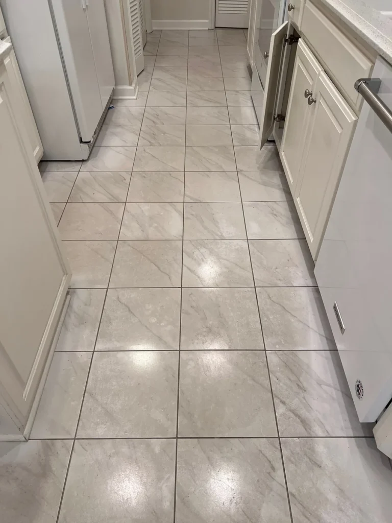 Kitchen tile floor with dark grout lines before cleaning